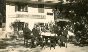 Gostje, zbrani pred gostilno Martina Černute v Logu pod Mangartom, ki je ohranila stari gostilniški izvesek, a morala v času pod Italijo slovenskemu napisu dodati še pripis v italijanščini. (E. Trinka, zasebna last)