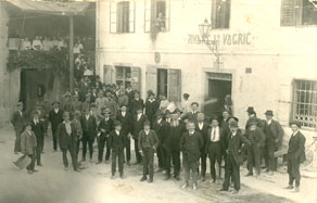 Do prepovedi rabe slovenskega jezika v javnih lokalih so bile gostilne pomembna kulturna in narodnobuditeljska središča. Na fotografiji iz leta 1921 so člani Bralnega in pevskega društva Slap ob Idrijci pred Vogričevo gostilno, ki je gostila prireditve domačega društva. (Arhiv Tolminskega muzeja)