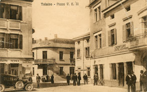 Uvajanje italijanščine v javno rabo je šlo postopoma: najprej so bili na javnih mestih še vidni slovenski napisi, kasneje so postali dvojezični, po 1926 pa strogo samo italijanski. Razglednica Tolmina je iz časa, ko je bila slovenščina na javnih mestih še dovoljena. (Arhiv Tolminskega muzeja)