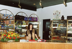 Velik čezmejni promet, obenem pa težke gospodarske razmere v Jugoslaviji, zaradi katerih je bil dobrodošel vsak priliv v tujih valutah, so v 80. letih 20. stoletja privedli do odpiranja brezcarinskih trgovin. Alpkomerc je imel svoje brezcarinske poslovalnice v vseh treh posoških centrih, moderno prodajalno pa je leta 1991 odprl tudi na najprometnejšem mejnem prehodu Robič. (Arhiv Tolminskega muzeja)