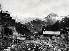 Južni vhod v Bohinjski predor. Zvon na leseni baraki je opozarjal na začetek in konec dela v izmenah. Južni vhod v Bohinjski predor. Zvon na leseni baraki je opozarjal na začetek in konec dela v izmenah.